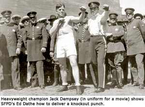 Jack Dempsey shows SFPD's Ed Dathe how to deliver a knockout punch