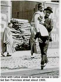 Child wearing Lotus shoes is carried across cobbled San Francisco street